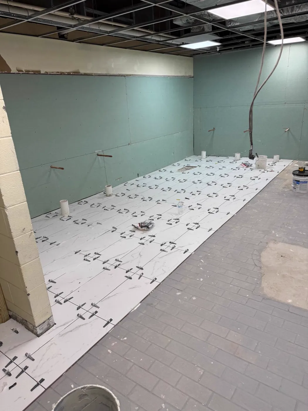 Finished shower with large-format marble-look tile walls, commercial venue renovation, Metro Atlanta