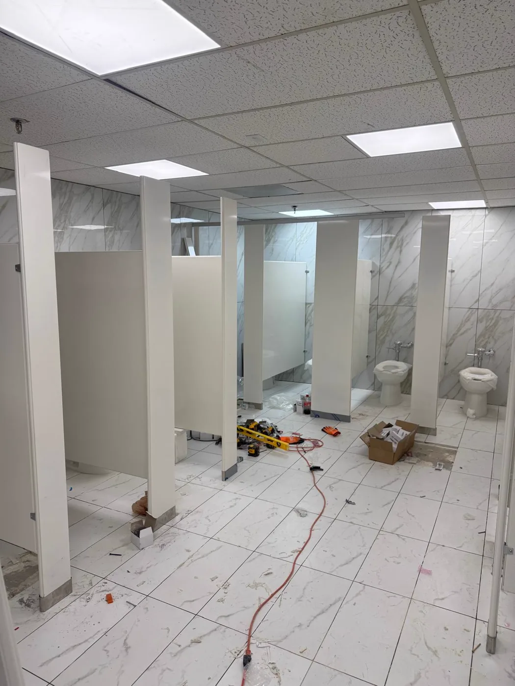Divisiones de baño siendo instaladas durante la renovación de un local comercial, Metro Atlanta