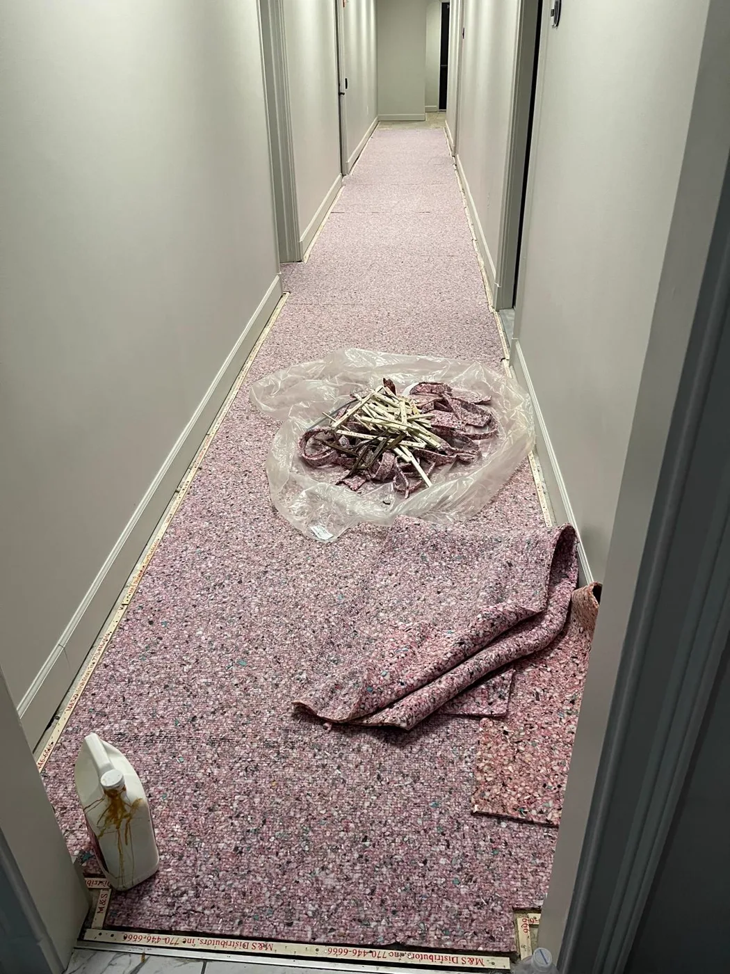 Alfombra antigua siendo retirada de un pasillo antes de la renovación de un local comercial, Metro Atlanta