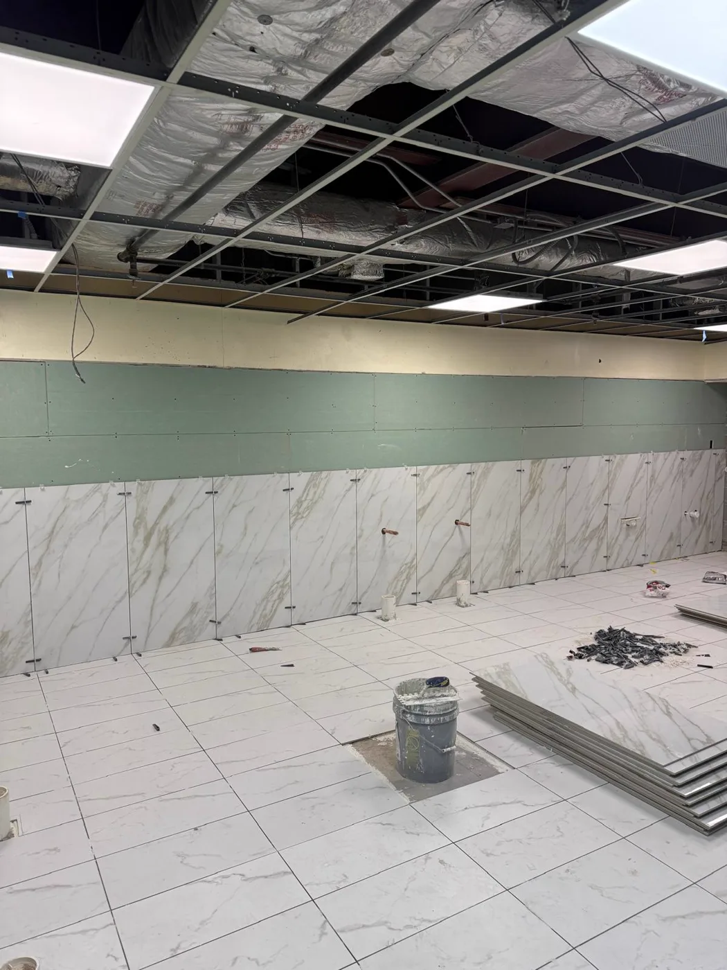 Paredes de mármol tipo zócalo siendo instaladas durante la renovación de un local comercial, Metro Atlanta