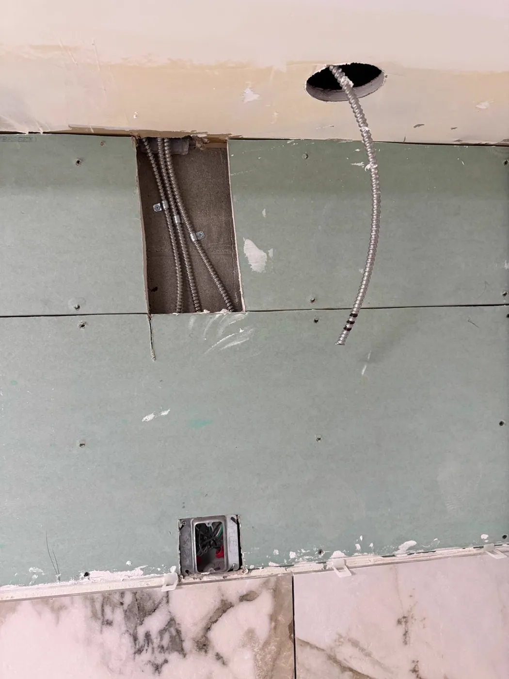 Electrical conduit run through a wall cavity above a finished backsplash, Metro Atlanta