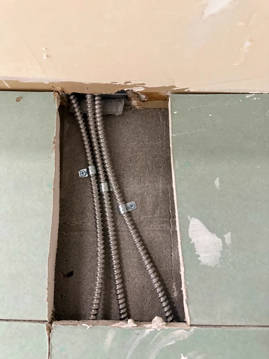 Tramos de conduit metálico flexible asegurados dentro de una cavidad de pared abierta, Metro Atlanta