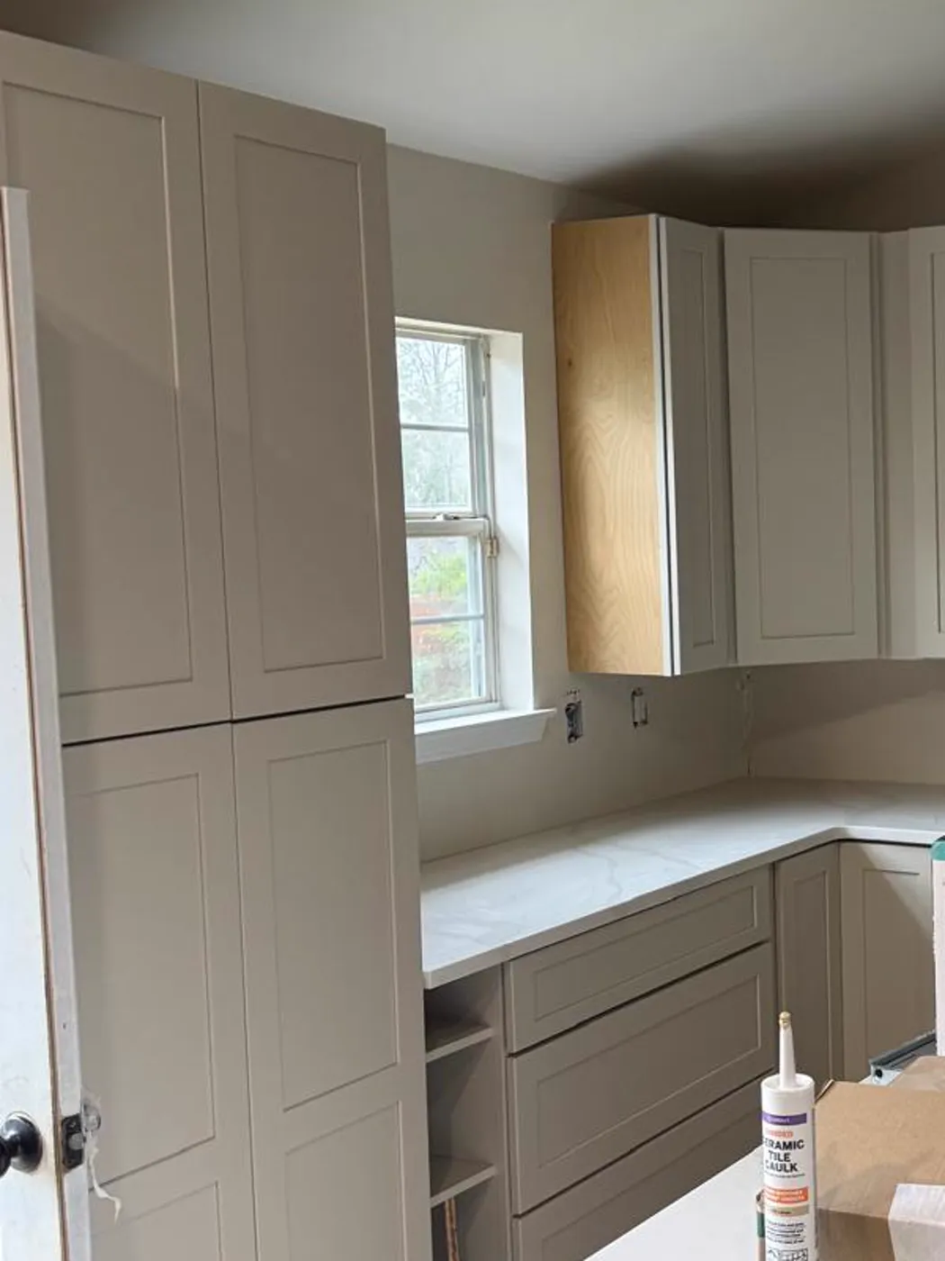 New kitchen cabinets with a marble-look countertop and a window over the counter run, Metro Atlanta