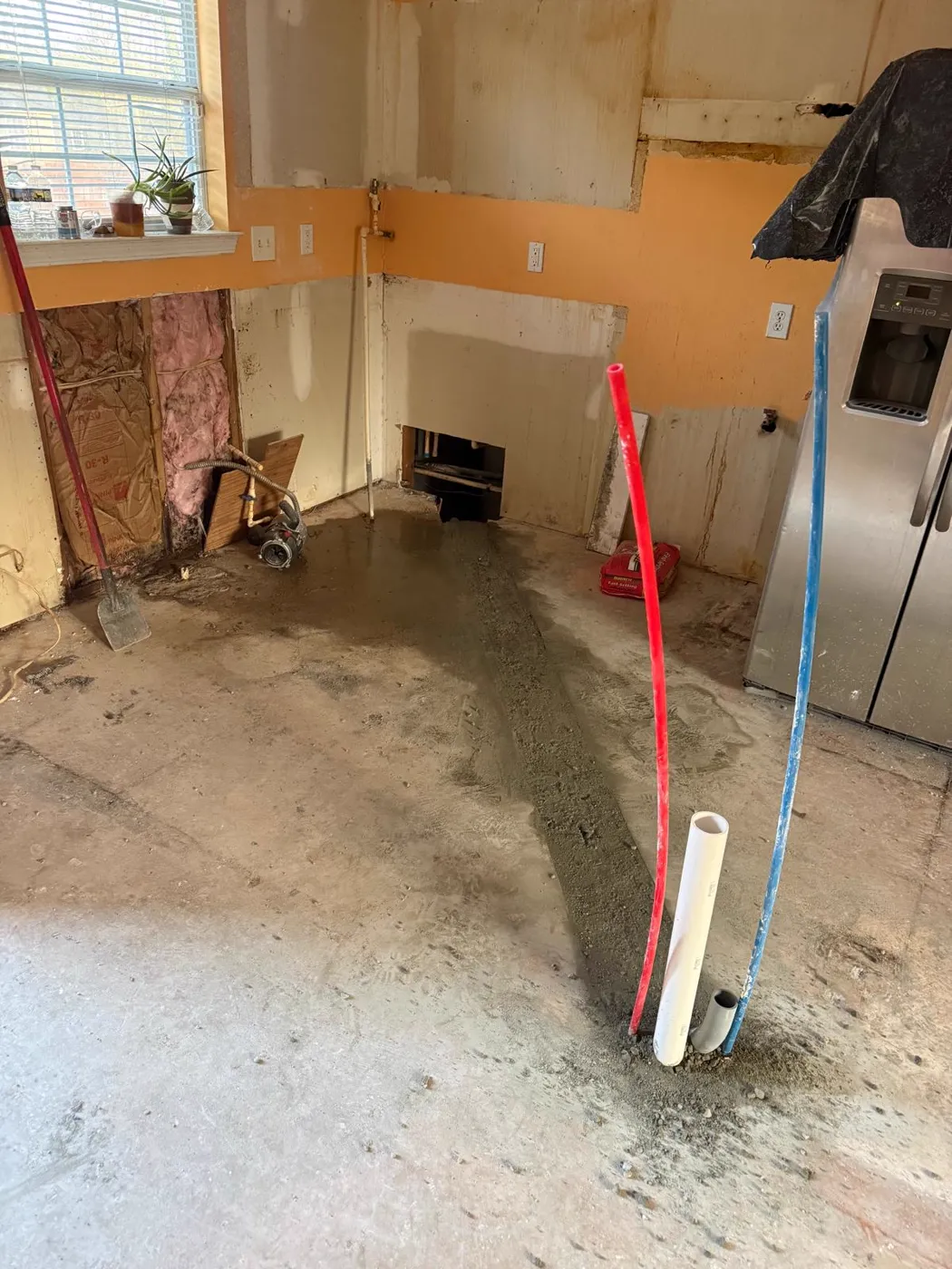Kitchen stripped to the slab during demolition with new supply lines run, Metro Atlanta