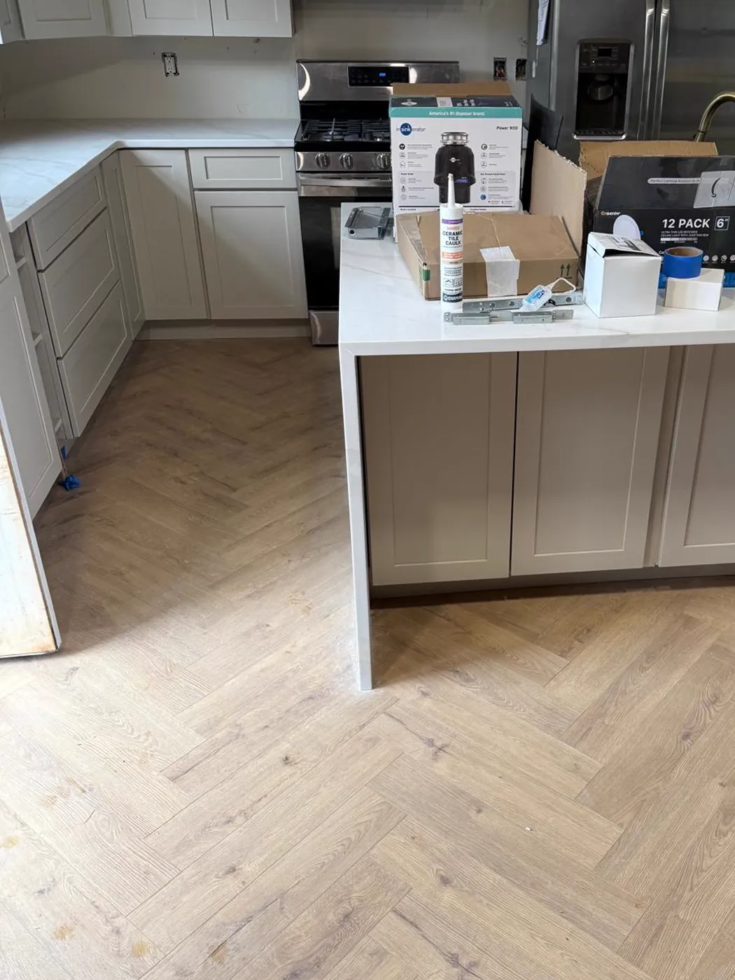 Finished kitchen with an island, new cabinets and a herringbone wood-look floor, Metro Atlanta