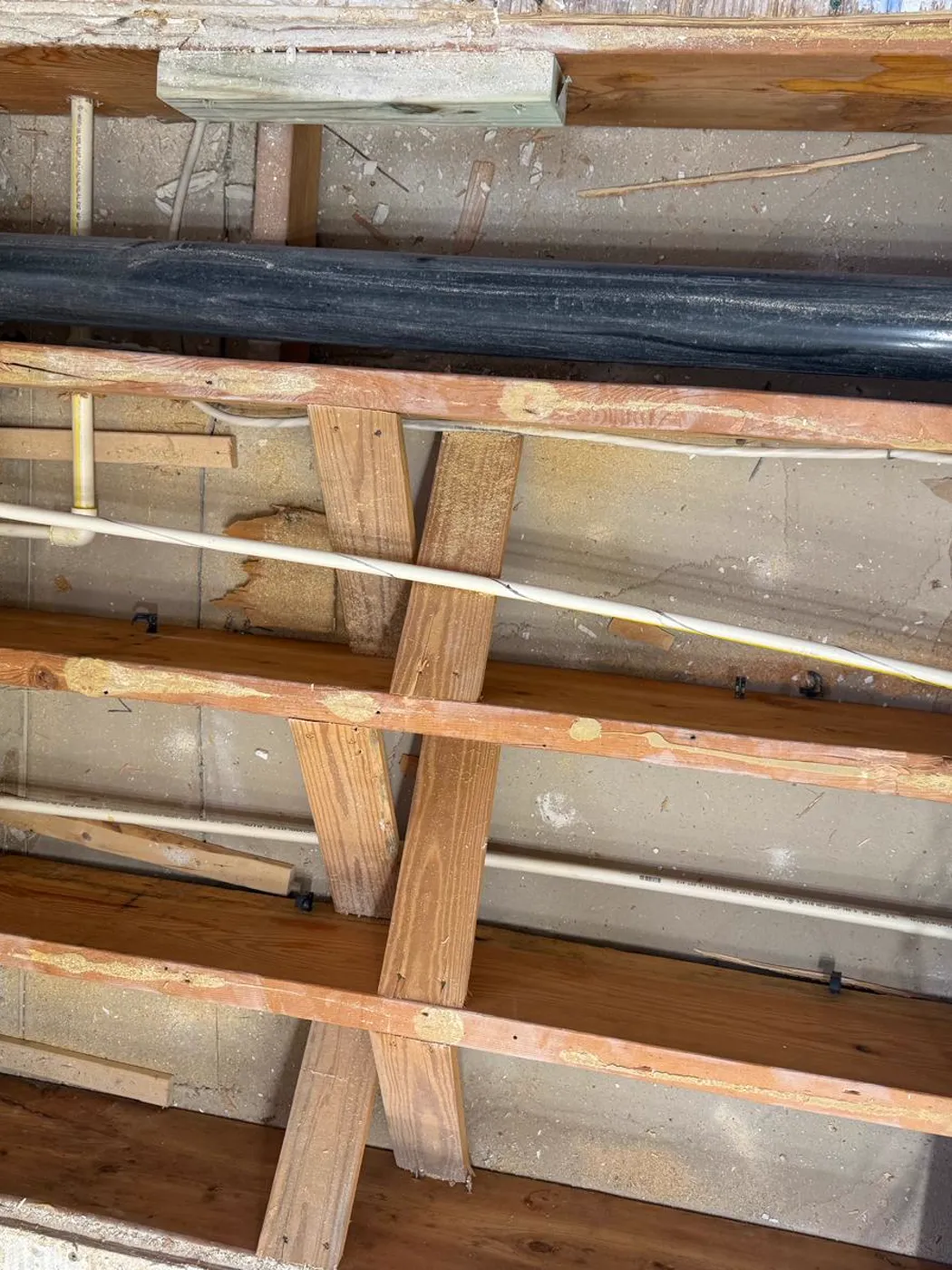 Nuevas líneas de plomería pasadas entre las viguetas del piso durante una renovación, Metro Atlanta