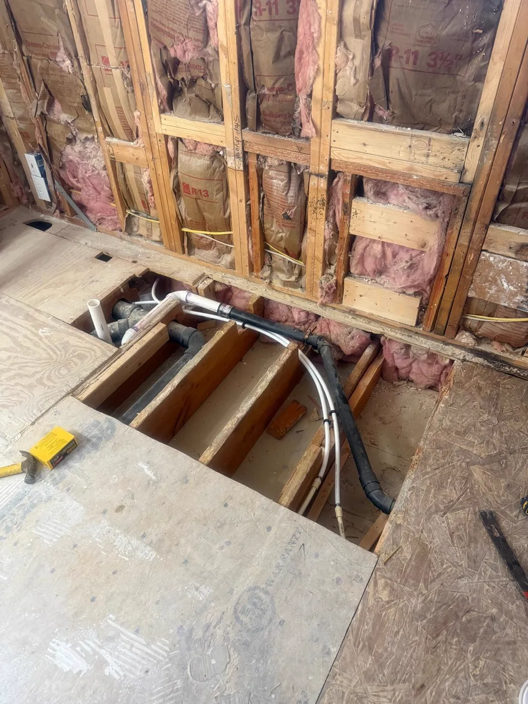 Subfloor opened to run new drain and supply lines between the joists, Metro Atlanta